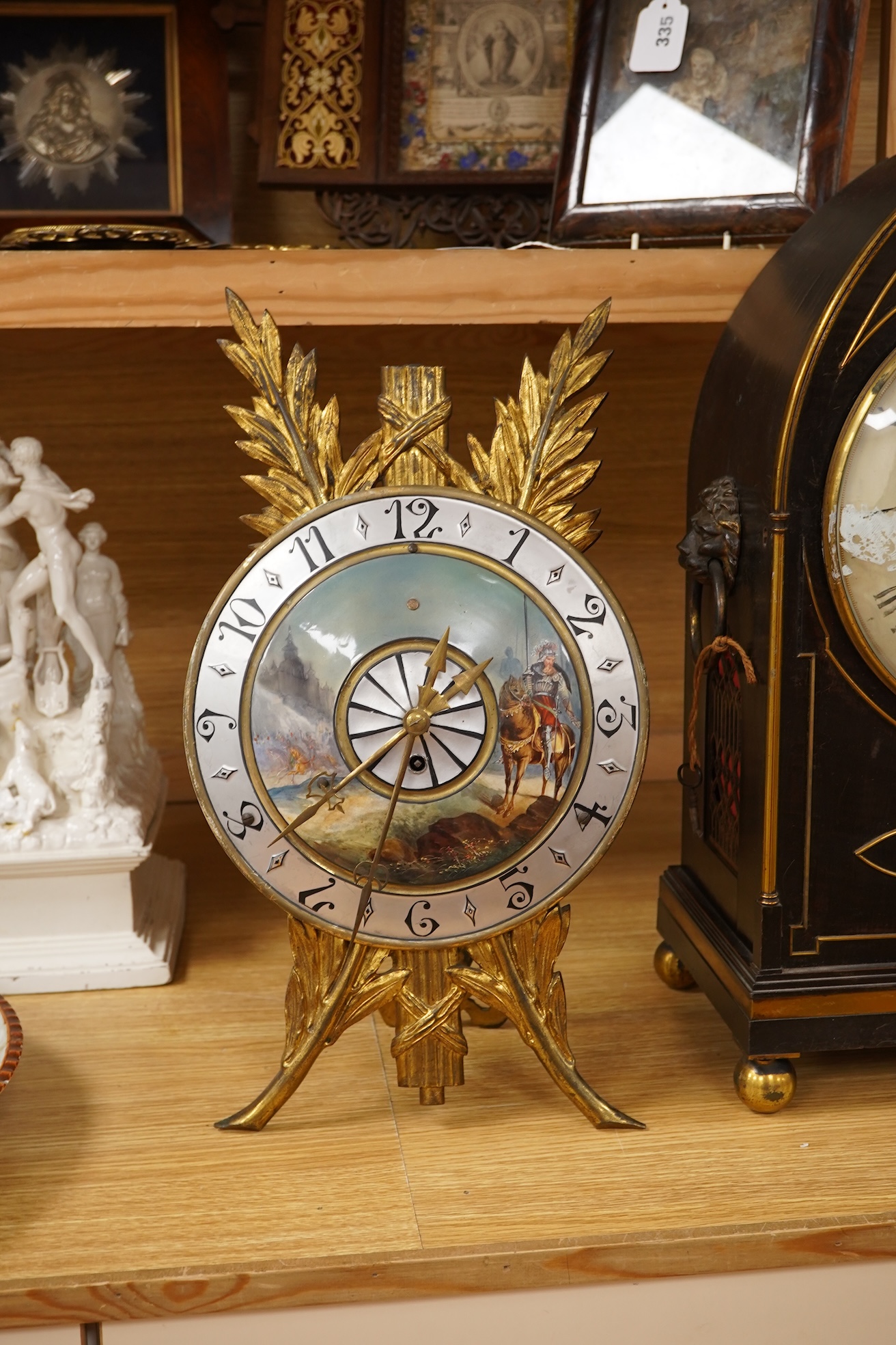 A Regency ebonised and brass inlaid lancet-shape bracket clock, with key and a painted pottery strut timepiece, largest 55cm high (2)